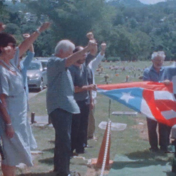 group of people raise fists at a funeral