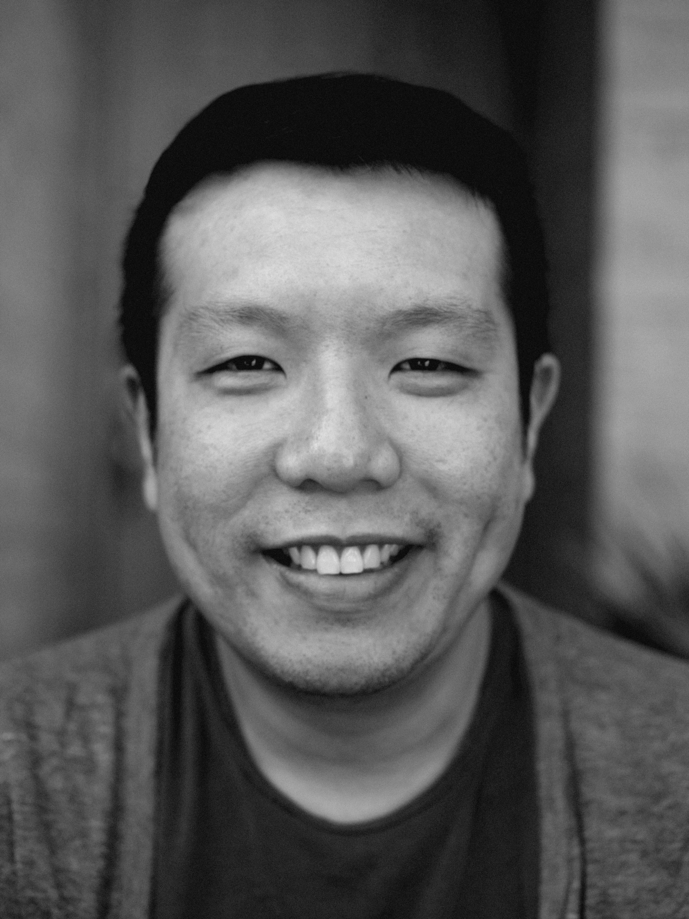 black and white photo of person with short hair smiling