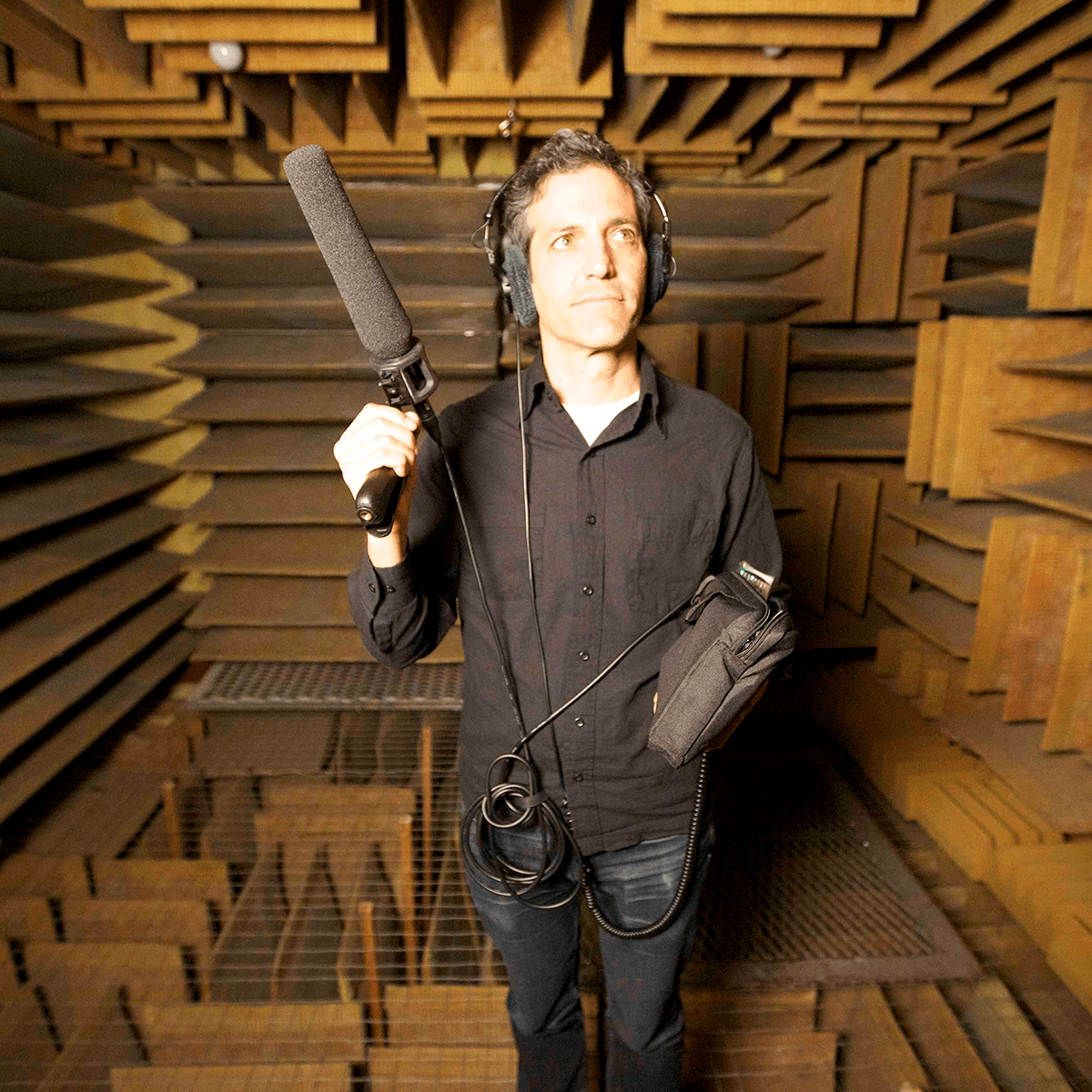 person holds recording equipment in a sound proof room