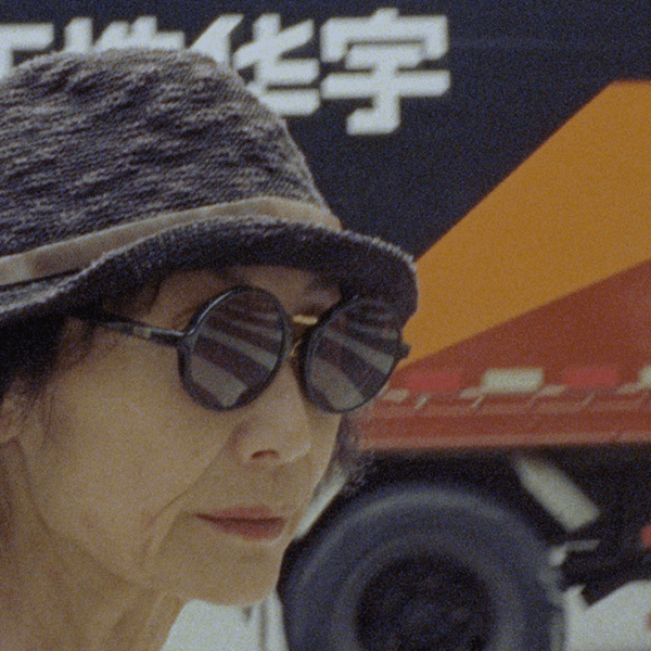 a person with glasses and a hat stands in front of a truck