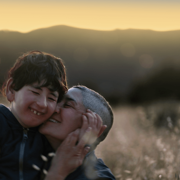 adult embraces child in a field