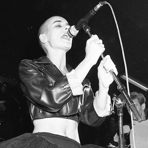 a person stands on stage singing into a microphone