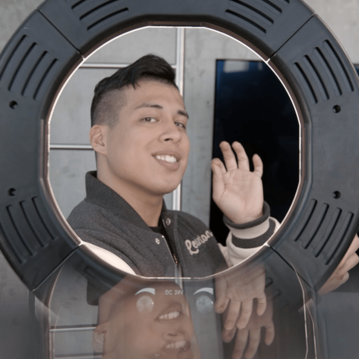 young adult records a video using a selfie ring light