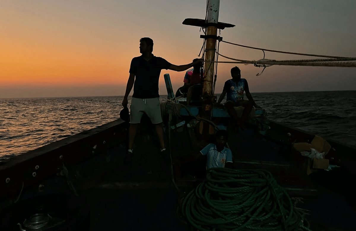 film still - men on a sailboat at sunset