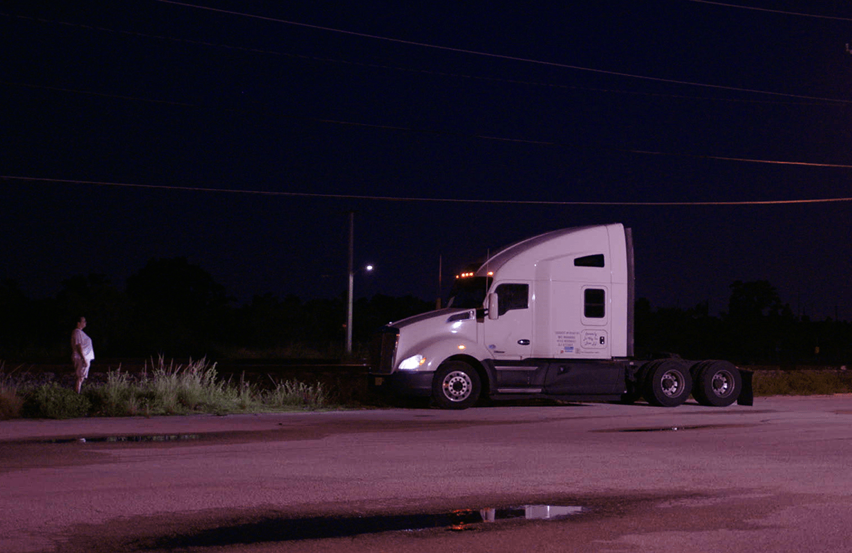 film still - semitruck parked facing person standing
