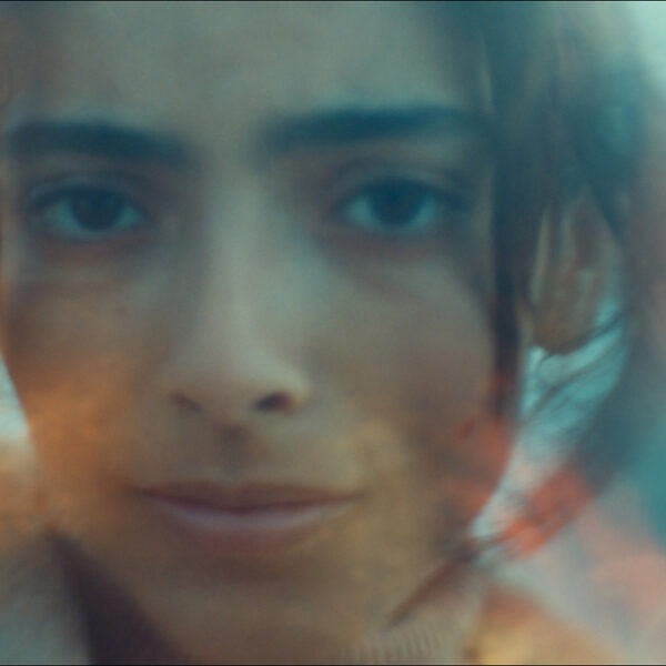 a brown haired woman subtly smiling.