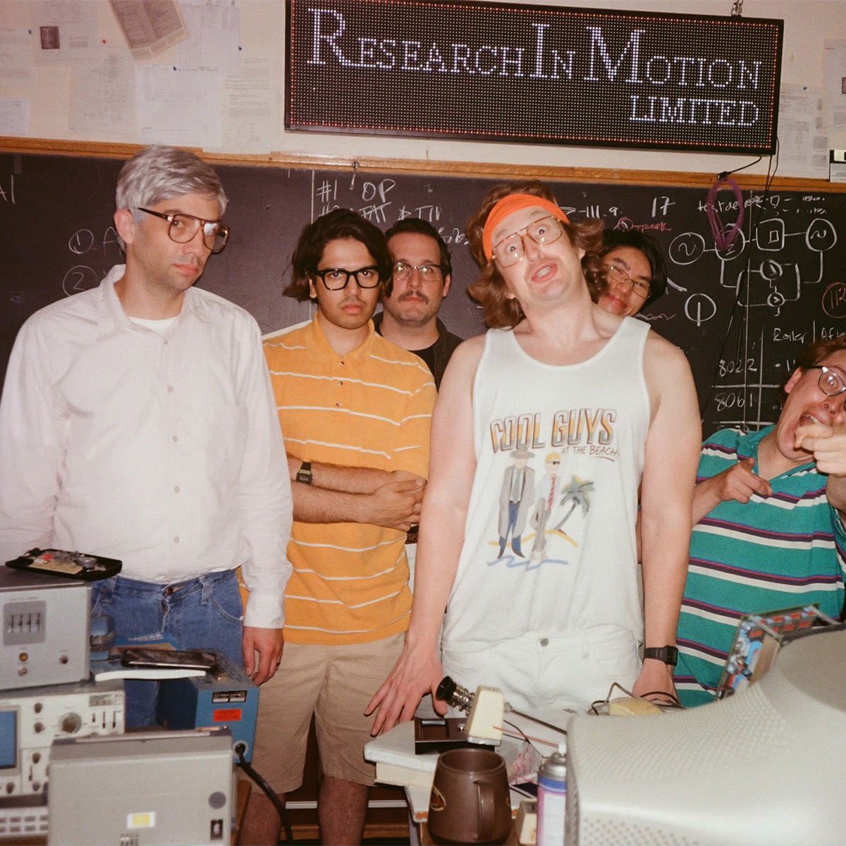 a group of men pose for a photo in front of a black board with a sign that reads "research in motion limited" above them.