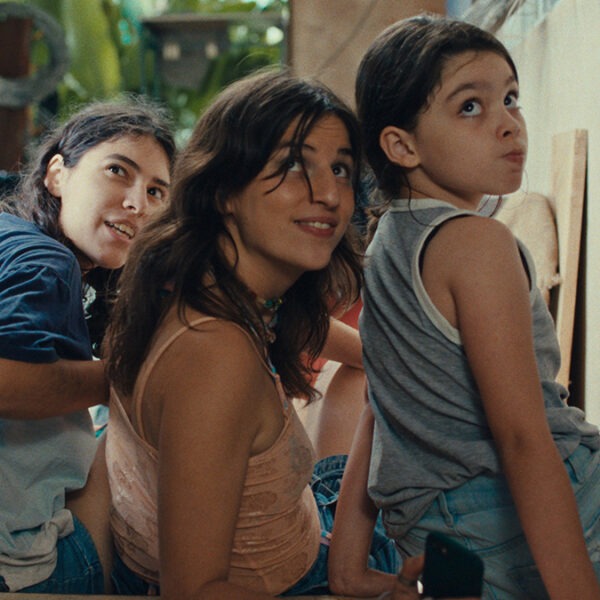 a woman and two children sitting together on the floor.