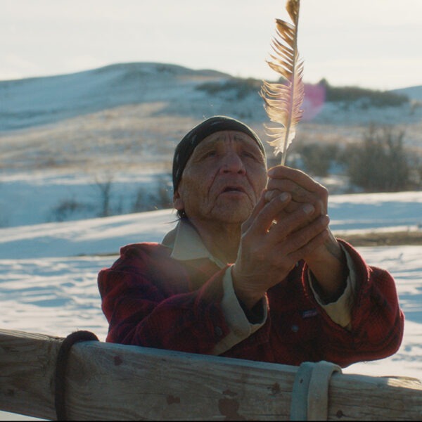 Woman in snow holding feather.
