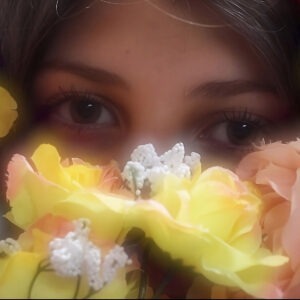 A woman's eyes surrounded by yellow and white flowers.