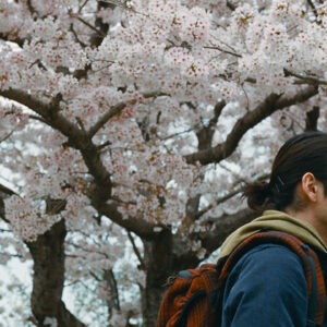 A man in front of a blooming tree.