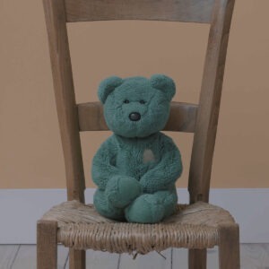 A blue stuffed toy bear on a chair.