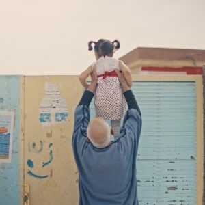 A man holding up a little girl.